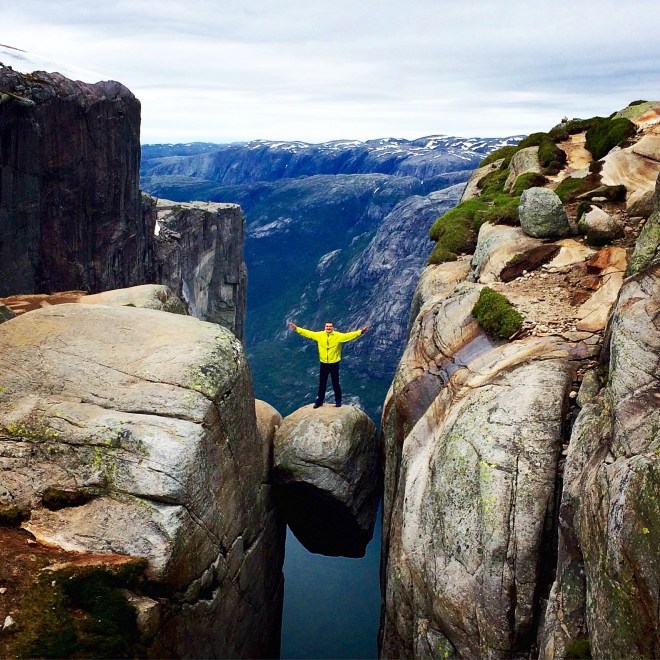 A man standing on Kjeragbolten, Rogaland, Norway © Scoundrelgeo with CCLicense